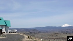 An off-grid home with a panoramic view showing Mount Jefferson appears in the Three Rivers Recreational Area, a 4,000 acre off-grid community in Lake Billy Chinook, Ore., on April 26, 2007. (AP Photo/Don Ryan, File)