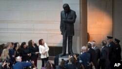 Daughter Rosanne Cash, center left, accompanied by other family members, looks up during the unveiling of a bronze statue of American singer-songwriter Johnny Cash, in Emancipation Hall at the Capitol in Washington, Sept. 24, 2024.