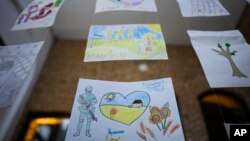 Children's drawings, the bottom one reading "Ukraine in the Heart" are presented at a UNICEF organized exhibition of drawings by Ukrainian refugee children and Romanian children in Bucharest, Romania, Jan. 31, 2023. 