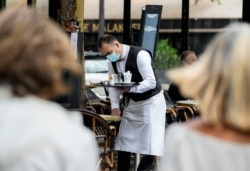 26일 프랑스 파리의 한 식당에서 마스크를 쓴 종업원이 서빙하고 있다.