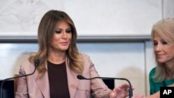 First lady Melania Trump and White House Counselor Kellyanne Conway, right, adjust a microphone while they participate in a roundtable discussion on the opioid crisis, on Capitol Hill in Washington, Oct. 23, 2019.