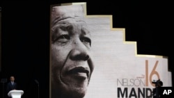 Mantan Presiden AS Barack Obama (kiri) menyampaikan pidatonya di Ceramah Tahunan ke-16 Nelson Mandela di Wanderers Stadium di Johannesburg, Afrika Selatan, Selasa, 17 Juli 2018, menjelang peringatan 100 tahun hari lahir tokoh antiapartheid Nelson Mandela. (AP Photo/Themba Hadebe)