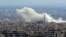 A general view taken from a government-held area in Damascus shows smoke rising from the rebel-held enclave of Eastern Ghouta on the outskirts of the Syrian capital following fresh air strikes and rocket fire on February 27, 2018. 