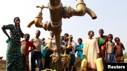 Des réfugiés congolais qui ont fui des affrontements entre l'armée congolaise et les combattants des Forces de l'Alliance Démocratique (ADF), s'assemblent autour d'une fontaine à la recherche de l'eau au camp de transit de Bukanga, à Bundibugyo, 376km de Kampala, juillet 17 2013. 