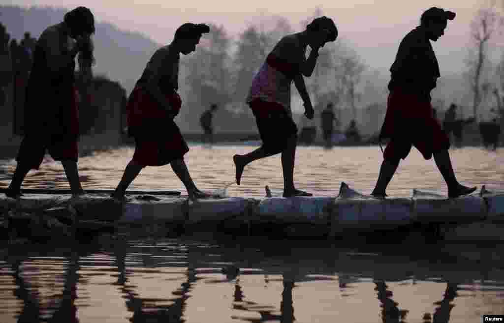 Devotees return after taking a holy bath in the Triveni River during the Swasthani Bratakatha festival in Panauti near Kathmandu, Nepal.