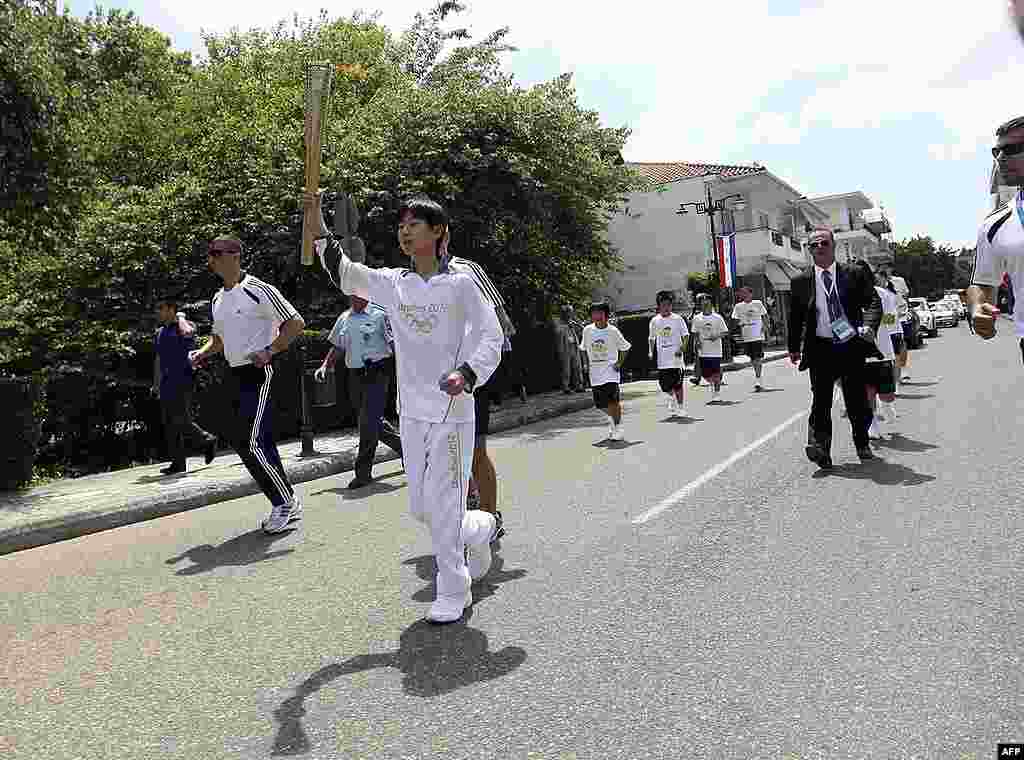 Torchbearer Yuya Umehara runs with the Olympic flame during the Olympic torch relay. (Reuters)