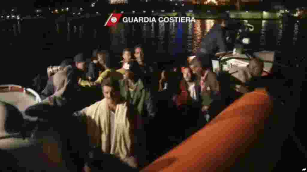 This image from video shows survivors of a ship that sank being transported on an Italian Coast Guard vessel as it arrives at port, Lampedusa, Italy, Oct. 3, 2013. (Italian Coast Guard)