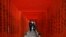 Pengunjung yang mengenakan masker pelindung wajah berjalan melalui gerbang torii kayu berwarna merah di sebuah kuil, di tengah wabah Covid-19, di Tokyo, Jepang, 22 Desember 2020. (Foto: Reuters)