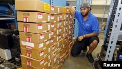 FILE - Parts department worker Frank Jorge stands next to boxes containing recalled Takata air bag inflators that were removed at the AutoNation Honda dealership in Miami, Florida, June 25, 2015.