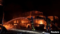 俄羅斯導彈襲擊基輔後，消防人員在一處受到導彈殘骸破壞的停車區試圖撲滅大火。(2023年5月16日)