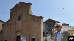 A man walks in front of a collapsed church in Mirandola, northern Italy, May 29, 2012.
