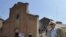 A man walks in front of a collapsed church in Mirandola, northern Italy, May 29, 2012.