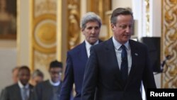 PM Inggris David Cameron, diikuti Menlu AS John Kerry, tiba di lokasi penyelenggaraan KTT Anti Korupsi di London, Inggris (12/5). 