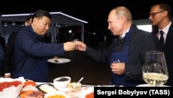 RUSSIA -- Russian President Vladimir Putin and Chinese President Xi Jinping toast during a visit to the Far East Street exhibition on the sidelines of the Eastern Economic Forum in Vladivostok, September 11, 2018