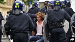 Police in riot gear drag a man along a street in Hackney, east London August 8, 2011