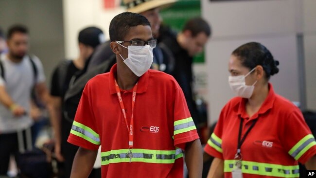在巴西圣保罗国际机场，工作人员戴着口罩预防新冠病毒传播。（2020年2月26日）