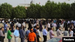 Egyptian nationals living in Kuwait stand in line at the entrance of the Egyptian Embassy before voting in Egypt's presidential elections, in Bnaid al-Gar, Kuwait, May 16, 2012.