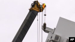 Emergency workers are lifted into the remains of the Pyne Gould Guinness building, which was destroyed following earthquake, in the southern New Zealand city of Christchurch, February 23, 2011