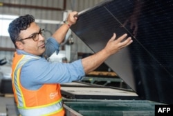 We Recycle Solar Chief Executive Officer Adam Saghei shows damaged solar panels to be recycled at the We Recycle Solar plant in Yuma, Arizona on December 6, 2023. (Photo by VALERIE MACON / AFP)