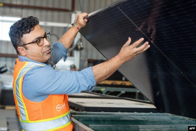 We Recycle Solar Chief Executive Officer Adam Saghei shows damaged solar panels to be recycled at the We Recycle Solar plant in Yuma, Arizona on December 6, 2023. (Photo by VALERIE MACON / AFP)