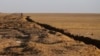 FILE - A long trench created by Kurdish forces to demarcate their border, is seen at an open field in the Nineveh plain, northeast of Mosul, Iraq. The sand berms and trenches snake across northern Iraq all the way to Syria.