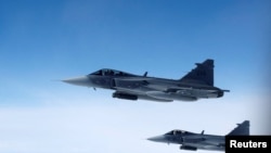 ARCHIVO - Aviones Saab JAS 39 Gripen de la Fuerza Aérea Sueca vuelan junto a una aeronave que simula intercepciones aéreas, durante una jornada de prensa que ilustra cómo la OTAN protege el espacio aéreo en la región norte y noreste de la Alianza, el 4 de julio de 2023.