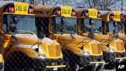 FILE - School buses are parked at the Skokie School District 68 parking lot in Skokie, Ill.