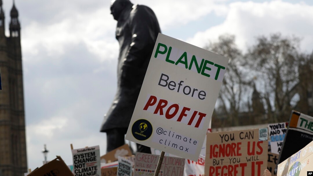ARSIP – Para pengunjuk rasa berunjuk rasa di depan patung Winston Churchill dengan mengusung poster di sekitar Gedung Parlemen di London, Inggris, 12 April 2019 (foto: AP Photo/Kirsty Wigglesworth, arsip)