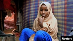 Nurta Mohamed, 13, a Somali girl sits inside her mother's makeshift shelter after she ran away from a suspected forced marriage at the Alafuuto camp for internally displaced persons in Garasbaaley district of Mogadishu, Somalia on Aug. 14, 2020. 