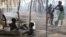 Children sit outside their family's tent as a neighbor bathes her son in a camp housing more than 2,600 Ivorian refugees in Solo Town, near Zwedrou, Liberia, May 25, 2011 (file photo).