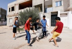 Boys play near the house of Fakher Hmidi in Thina district of Sfax, Tunisia, Oct. 15, 2019.