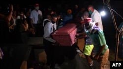 Relatives and friends of a mother and son mourn their deaths while attending his funeral at La Salina cemetery, Dec. 16, 2020 in Guira, Venezuela, after both drowned in a shipwreck.