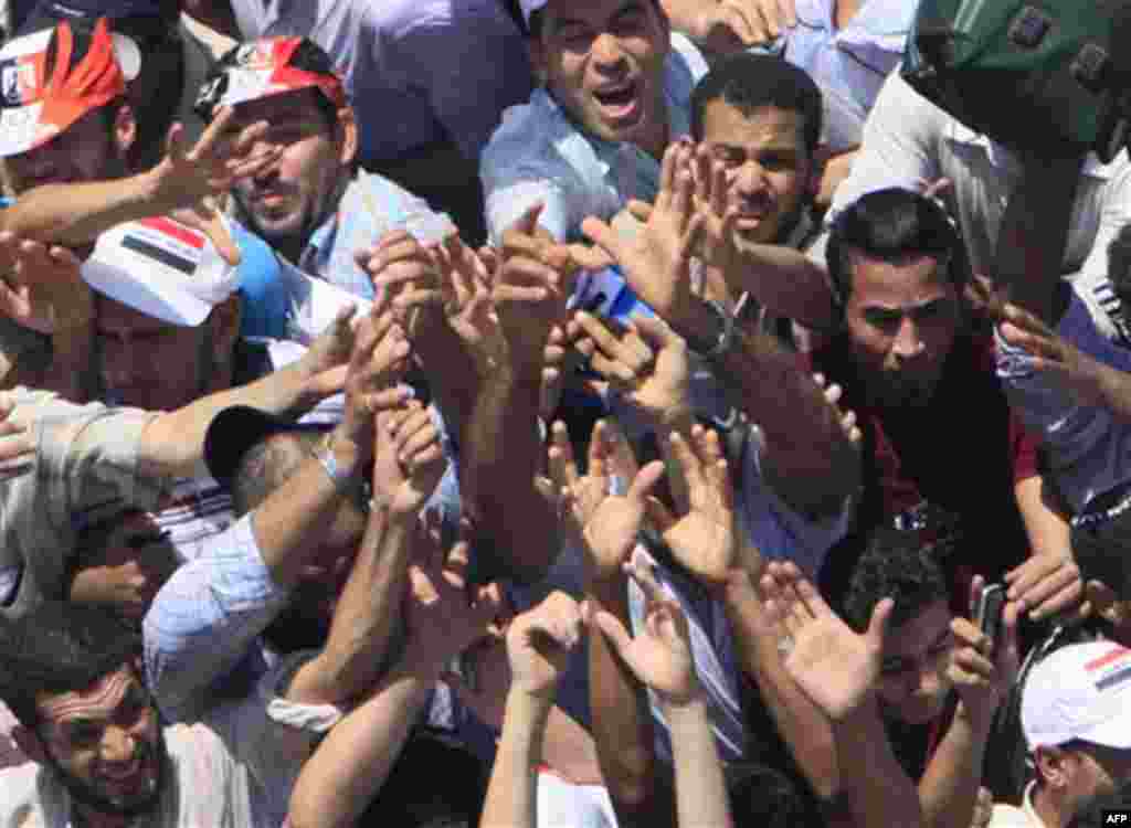 Egyptian protesters raise their hands to receive free water bottles during their protest at Tahrir Square, the focal point of Egyptian uprising, in Cairo, Egypt, Friday, July 29, 2011. Thousands of Egyptians rallied in Cairo's central Tahrir Square on Fri