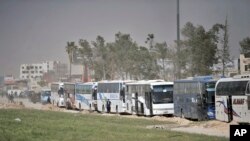 Konvoi bus pemberontak dan keluarga mereka meninggalkan beberapa kota dan desa di wilayah Ghouta timur dekat Damaskus, Suriah, 28 Maret 2018. (Foto: SANA via AP/dok).