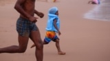 Beach-goers enjoy New Year's Day in the rain, on the beach in Durban