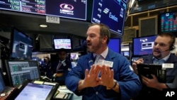 Specialist Charles Boeddinghaus, center, and trader Michael Milano work on the floor of the New York Stock Exchange, Oct. 24, 2018. 