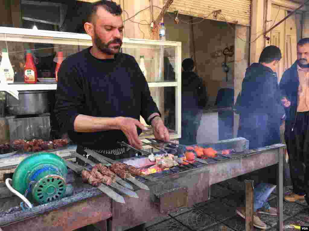 Wani namiji a kasuwar Mosul na dafa naman kabobs, a Iraqi ranar 23 ga watan Fabrairu, 2017 (K. Omar/VOA) &nbsp;