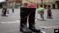 ARCHIVO - Botas con alambre de púas entrelazadas en representación de personas desaparecidas se exhiben en la plaza Bolívar en conmemoración del Día Internacional de los Desaparecidos, en Bogotá, Colombia, el 30 de agosto de 2023.