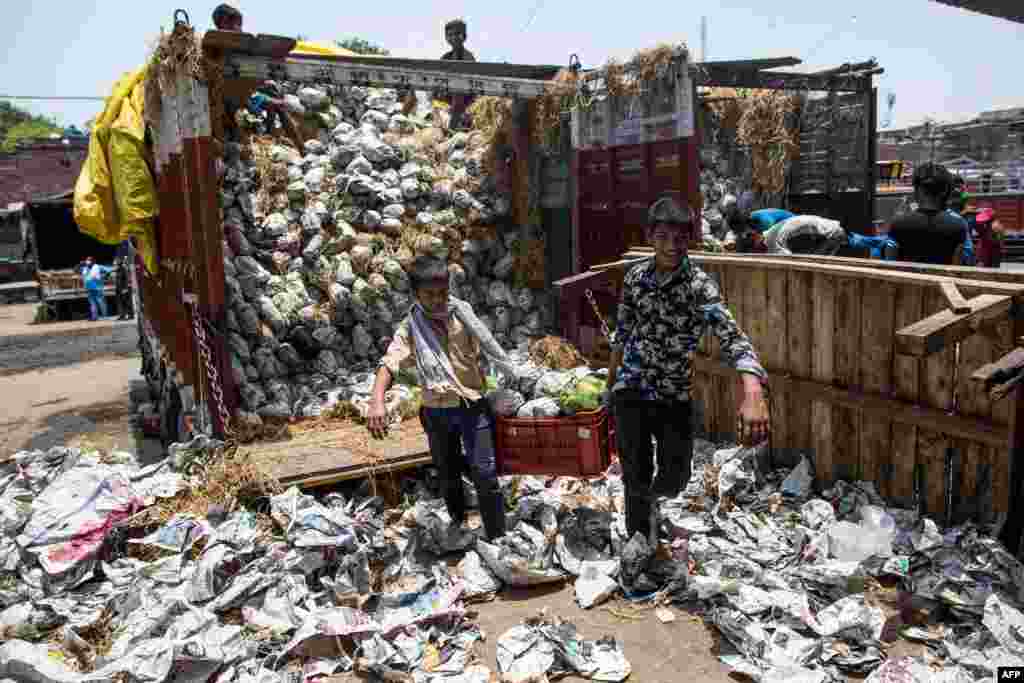 Children unload a truck carrying papayas at Okhla wholesale vegetable market in New Delhi, India.