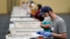 Workers prepare mail-in ballots for counting, Nov. 4, 2020, at the convention center in Lancaster, Pa., following Tuesday's election. 