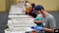 Workers prepare mail-in ballots for counting, Nov. 4, 2020, at the convention center in Lancaster, Pa., following Tuesday's election. 