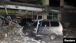 Reruntuhan gedung di Perguruan Tinggi dan Teknologi Negeri Surigao tampak menimpa sebuah mobil setelah gempa melanda kota Surigao (10/2). Surigao, Filipina Selatan. (foto: REUTERS/Roel Catoto-Mindanews)