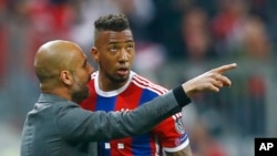 Bayern's head coach Pep Guardiola, left, instructs Bayern's Jerome Boateng during the soccer Champions League quarterfinal second leg match between Bayern Munich and FC Porto at the Allianz Arena in Munich, southern Germany, Tuesday, April 21, 2015. (AP P