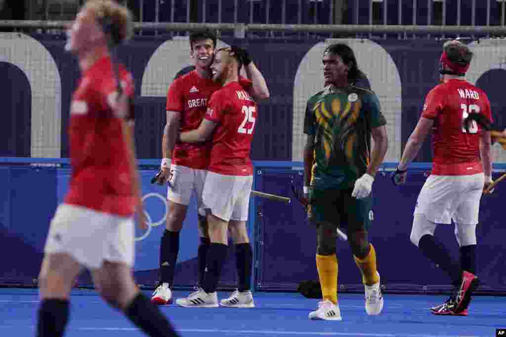 Great Britain&#39;s Phillip Roper, left, embraces Jack Waller (25) after Waller scored against South Africa during a men&#39;s field hockey match at the 2020 Summer Olympics, Saturday, July 24, 2021, in Tokyo, Japan. (AP Photo/John Locher)