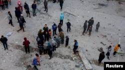 Palestinians inspect the damage in the aftermath of an Israeli strike on a school sheltering displaced people, amid the Israel-Hamas conflict, in Khan Younis in the southern Gaza Strip, Dec. 16, 2024.