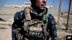 A member of the federal police smokes a cigarette during a break in fighting against Islamic State militants, in Hamam al-Alil, Iraq, Feb. 19, 2017. 