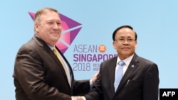 Menlu AS Mike Pompeo (kiri) berjabatan tangan dengan Menlu Myanmar Kyaw Tin di Singapura, 4 Agustus 2018. 