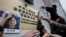 FILE - Activists paste photos of missing booksellers, one of which shows Gui Minhai at left, during a protest outside the Liaison Office of the Central People's Government in Hong Kong, Jan. 3, 2016.