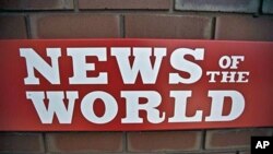 A News of the World sign is seen by an entrance to a News International building in London, Wednesday, July 6, 2011