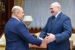 Russian Prime Minister Mikhail Mishustin (left) meets with Belarusian President Alexander Lukashenko in Minsk on April 16.